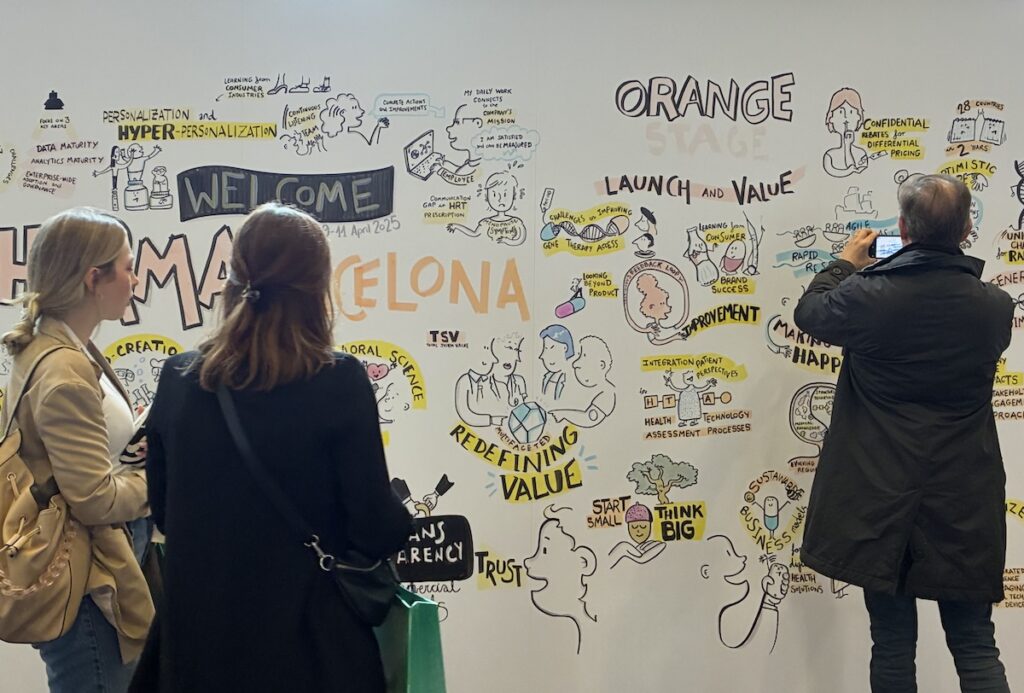 Participantes de un congreso farmacéutico fotografiando y analizando la intervención de graphic recording.