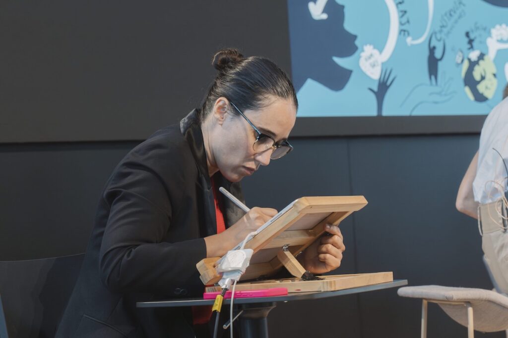Marina Marisma dibuja en directo con tablet durante un evento de Mujeres en Farma